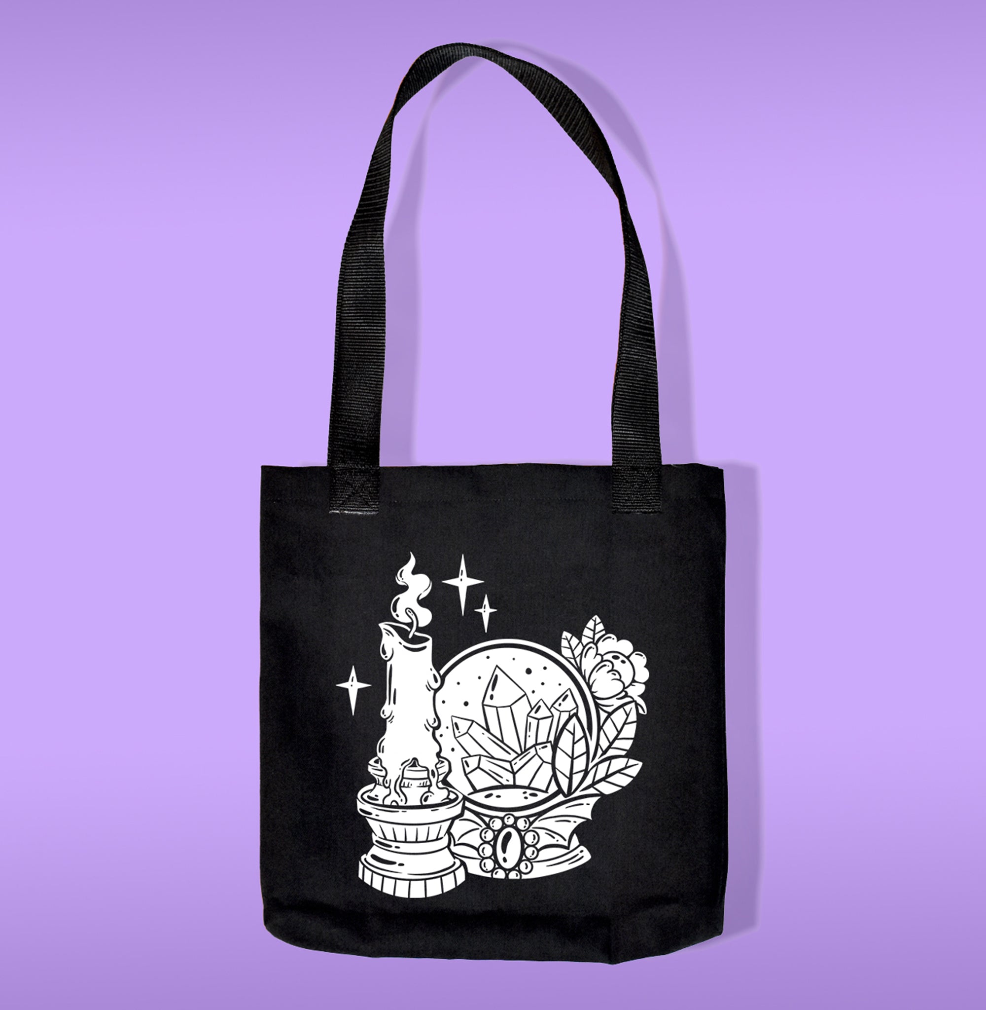 A black canvas bag with polypropelene straps. Features a candle and a crystal ball heat transfer print