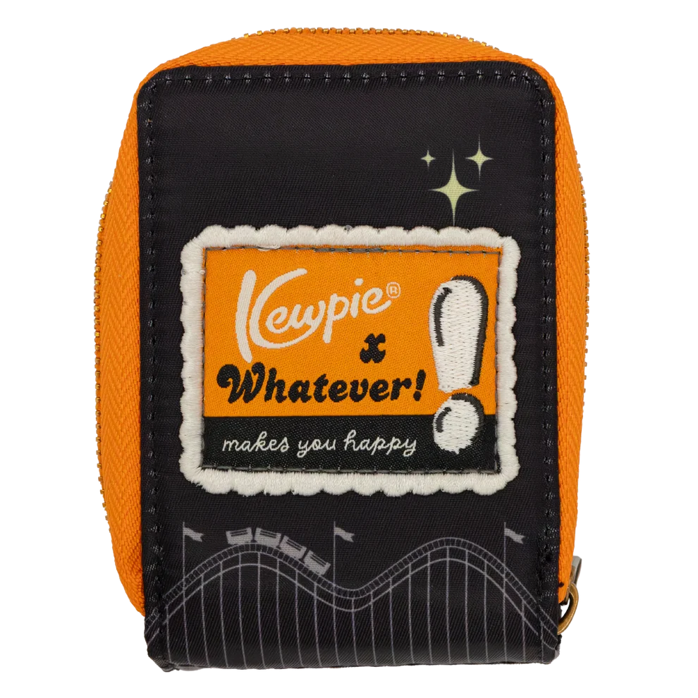 A small zippered pouch with a black front panel and bright orange sides, featuring a central embroidered patch that reads 'Kewpie x Whatever! makes you Happy' with a white exclamation mark and stadium graphic near the bottom.