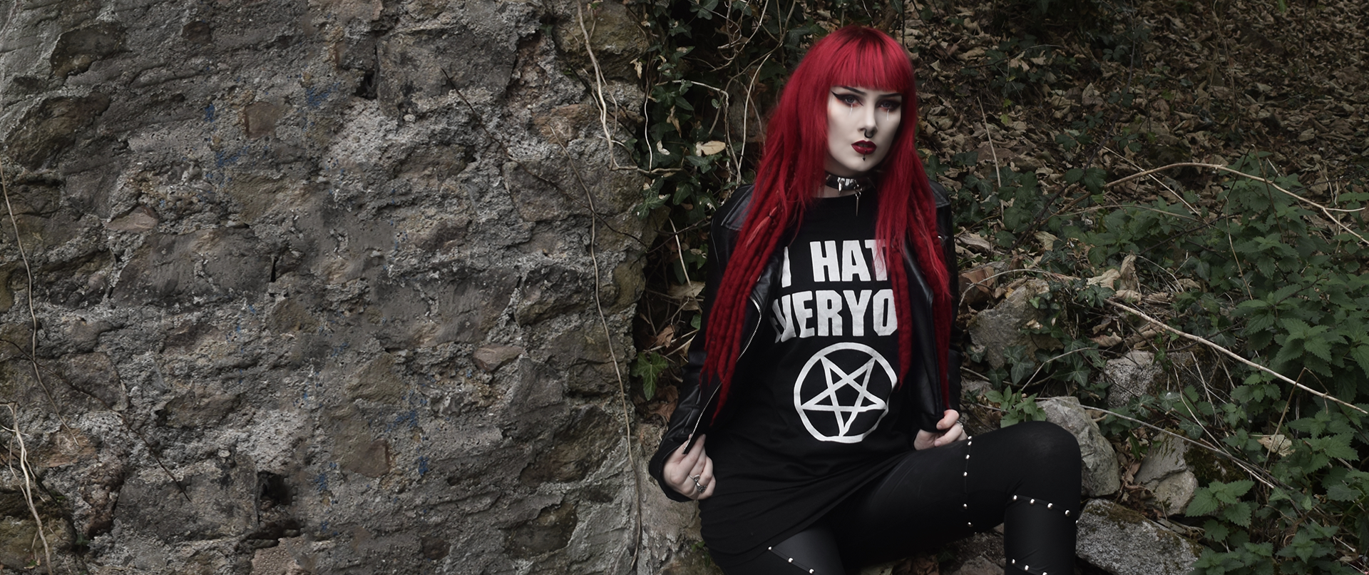 Girl sitting down posing as she shows off Belial Clothing Co's "I hate everyone" Tee shirt