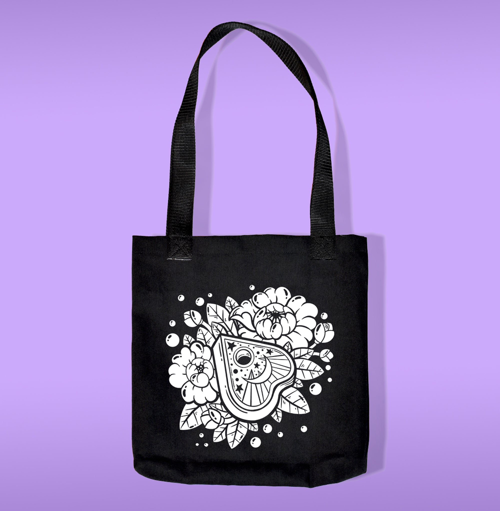 A black canvas bag with polypropelene straps. Features a planchet with flowers heat transfer print