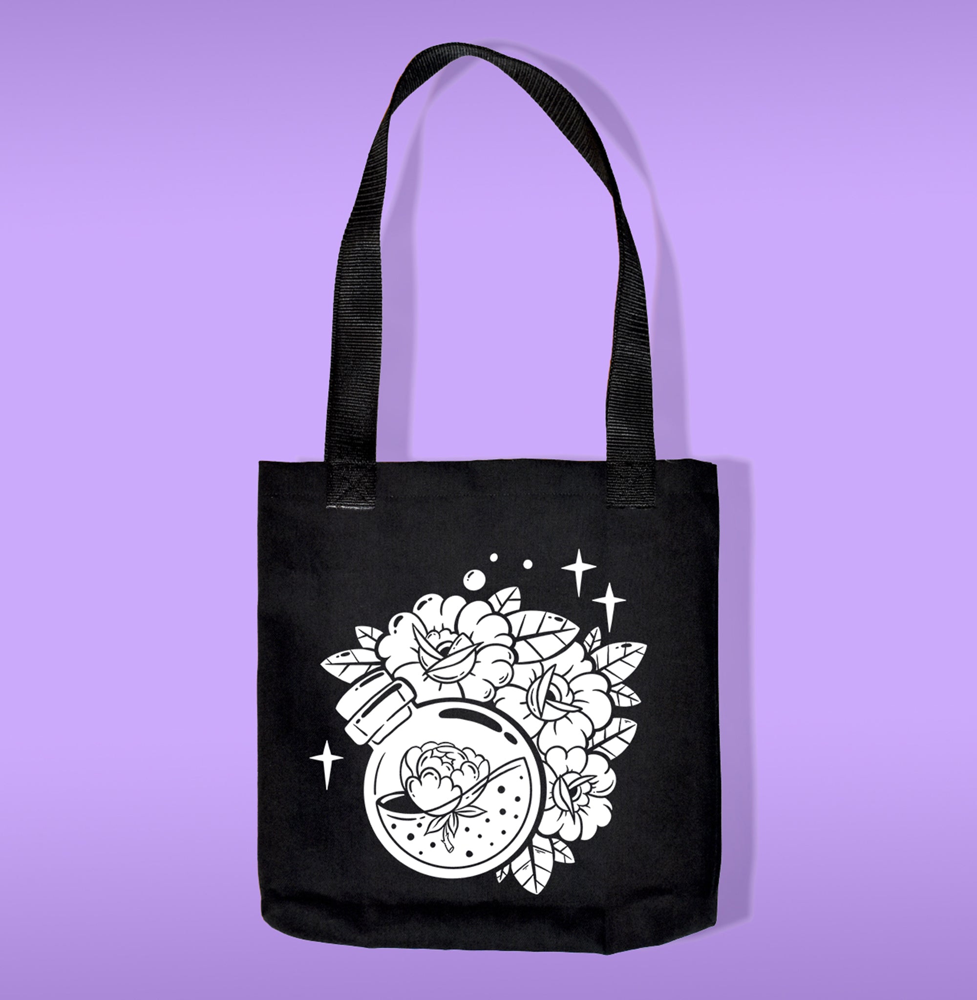 A black canvas bag with polypropelene straps. Features a caldron on a bottle filled with a lotus with flowers heat transfer print
